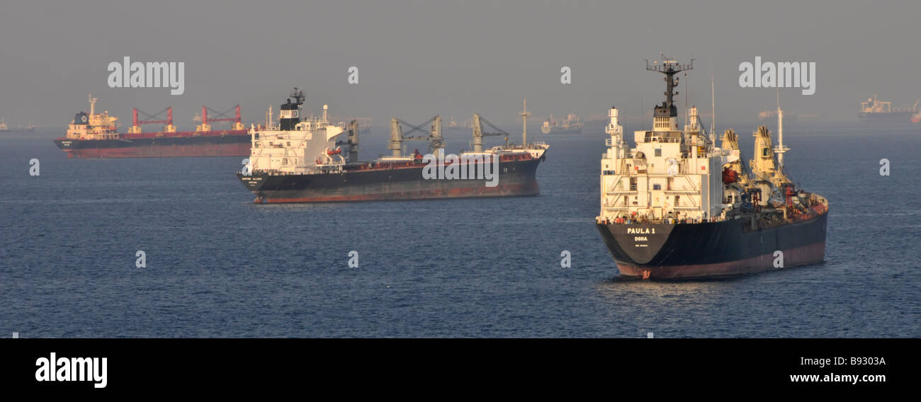 Transport à vide dans les vraquiers à brume thermique et les pétroliers mouillage des eaux côtières au large du port de soutage Fujairah des Émirats arabes Unis Golfe d'Oman près du détroit d'Ormuz Banque D'Images