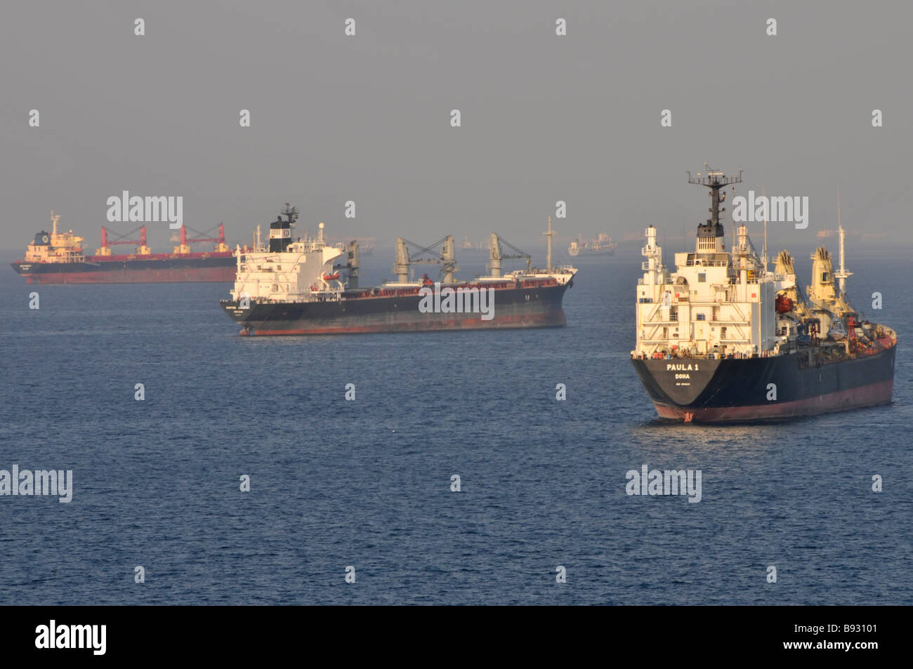 Navires à vide y compris des vraquiers et des pétroliers à l'ancre au large des côtes de Dubaï dans le golfe d'Oman, près de Détroit d'Ormuz vue dans le lointain de la brume sèche Banque D'Images