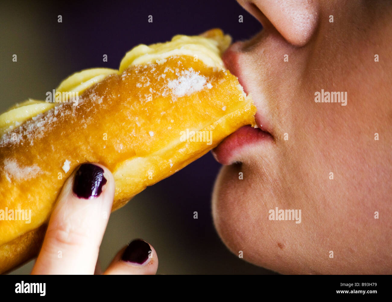 Femme mangeant un gâteau à la crème Banque D'Images