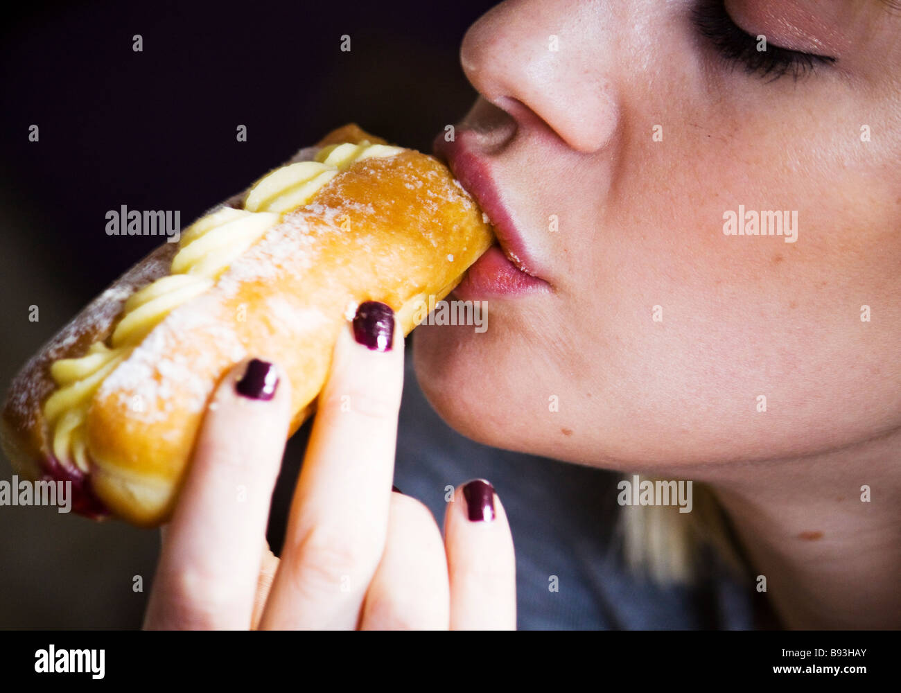 Femme mangeant un gâteau à la crème Banque D'Images