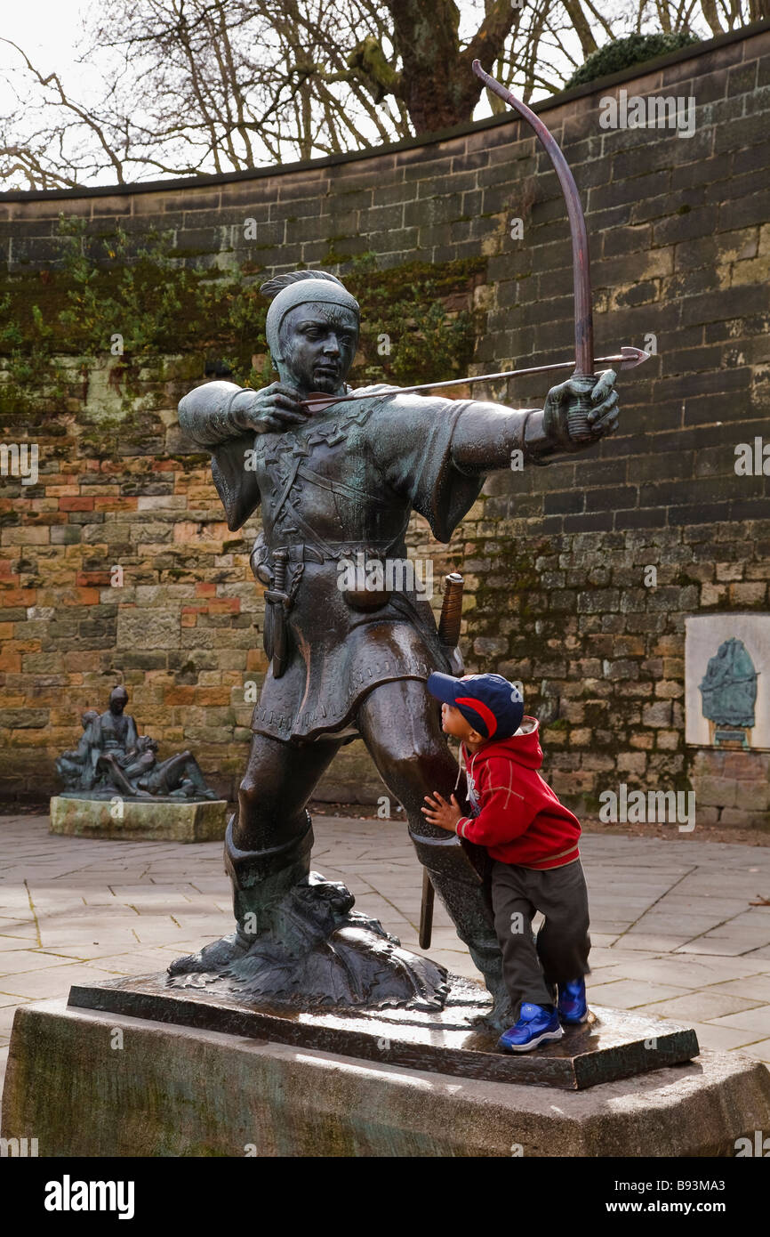 Enfant jouant sur la statue de Robin des Bois à l'extérieur du château de Nottingham, Nottingham, England, UK Banque D'Images