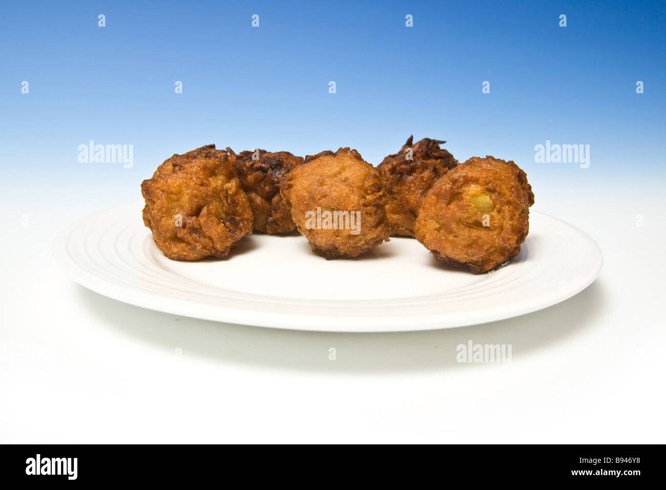 Onion Bhaji s sur un fond studio bleu Banque D'Images