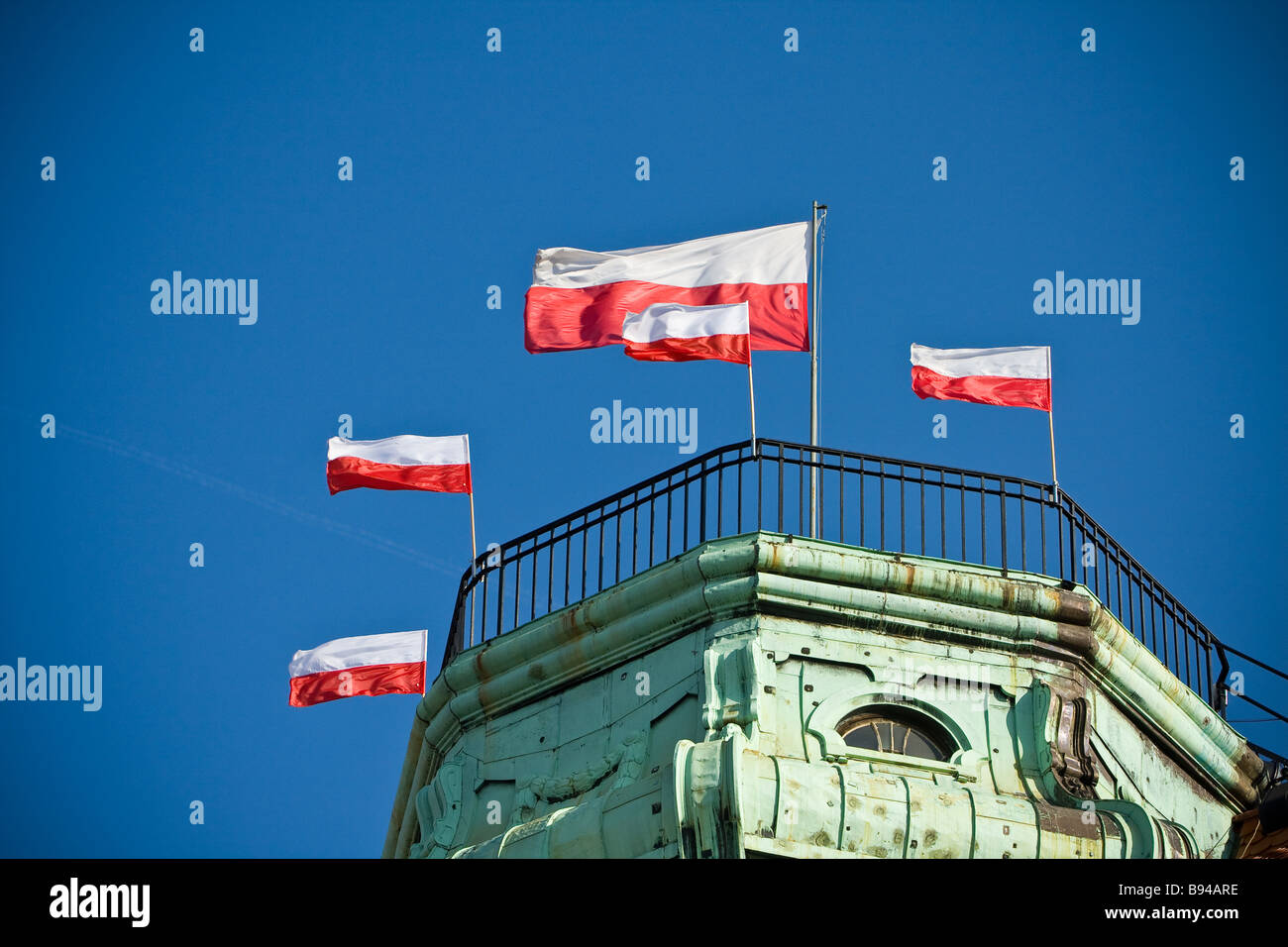 Brandissant des drapeaux polonais on blue sky Banque D'Images