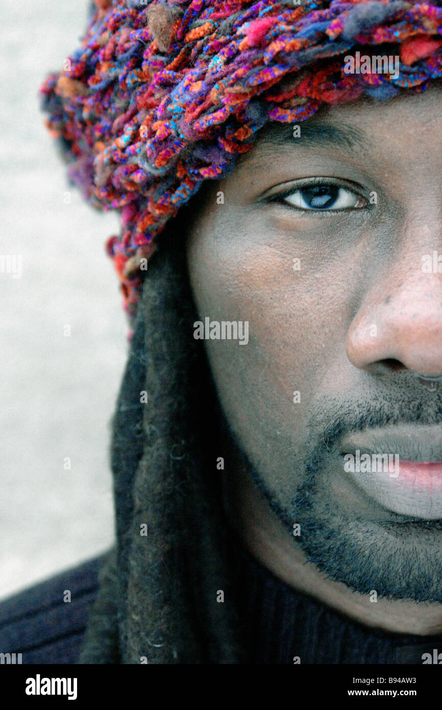 Portrait d'homme de noir origine Africaine avec des dreadlocks. Il porte un  chapeau foulard multicolore autour de sa tête Photo Stock - Alamy