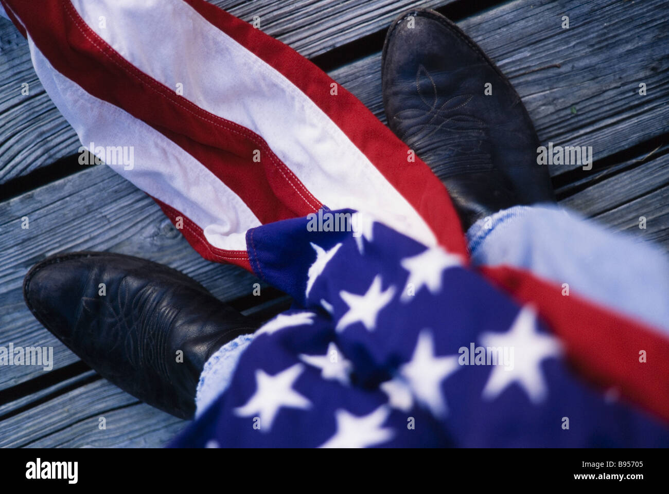 Bottes de cow-boy avec le drapeau américain, et Weathered Wood background. Banque D'Images