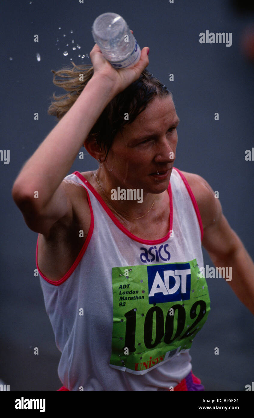 Sportifs Athlétisme Marathon de Londres Marathon de Londres en concurrent femelle verser une bouteille d'eau sur sa tête pour se rafraîchir. Banque D'Images