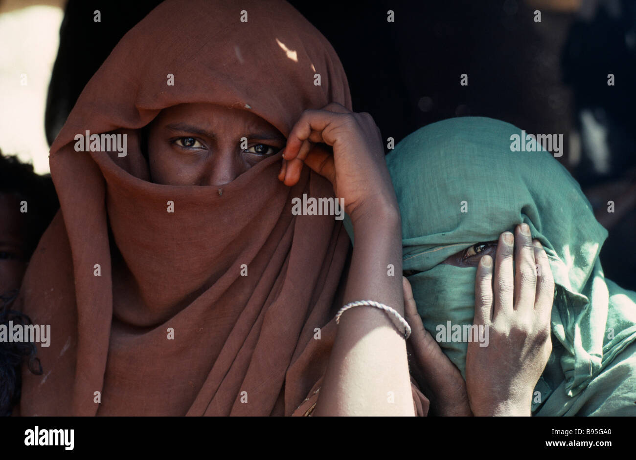 Soudan Afrique de l'Est les collines de la mer Rouge de la tête et des épaules les gens portrait de deux jeunes filles arabes nomades beja voilée avec les yeux seulement visible Banque D'Images