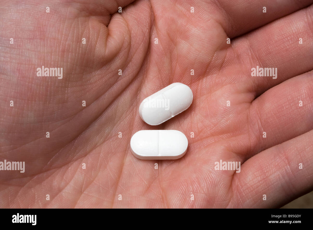 Deux pilules antidouleur dans la main Banque D'Images
