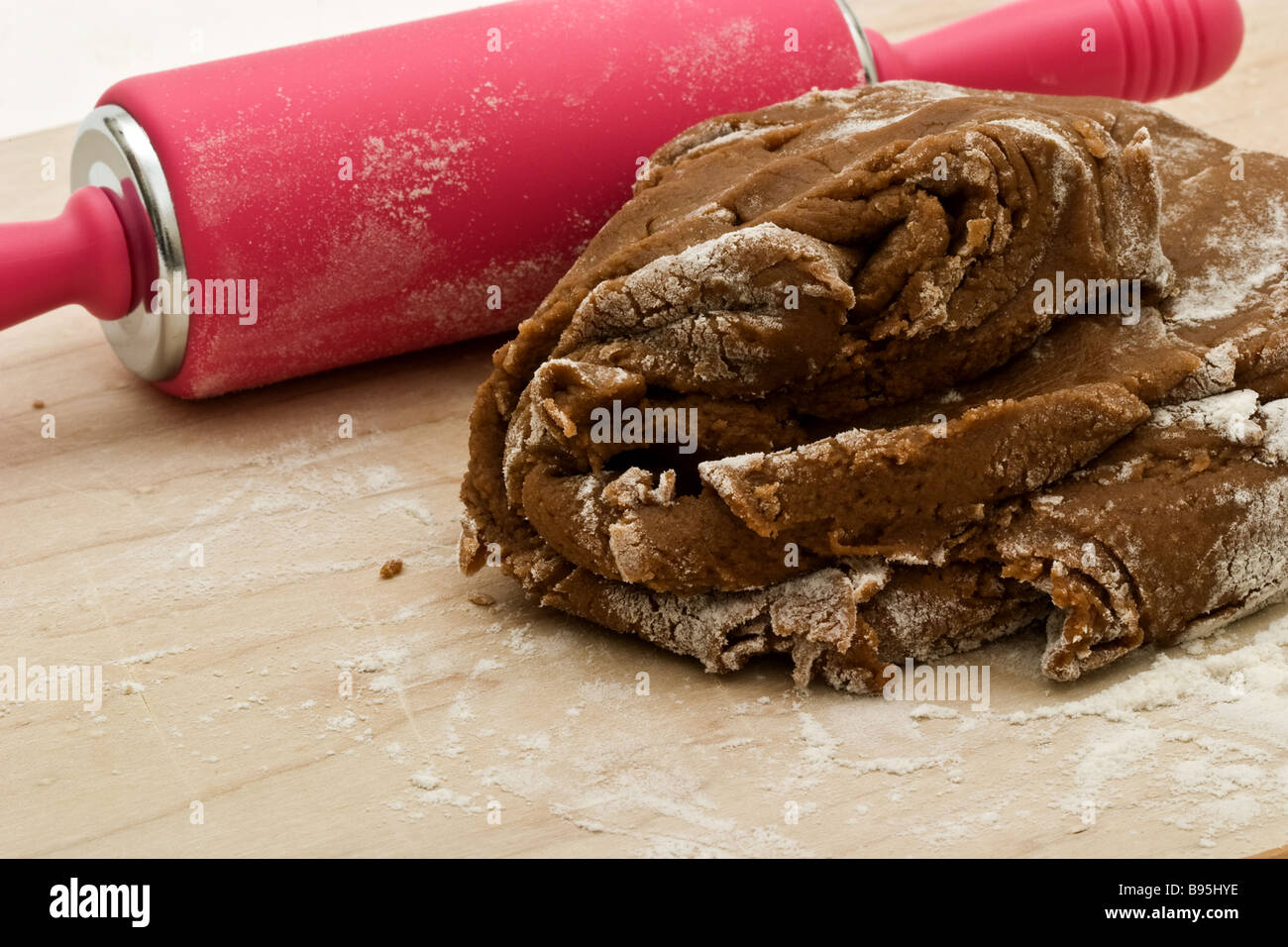 Rouleau à pâte rose et gingerbread cookie pâte sur une planche à découper en bois Banque D'Images