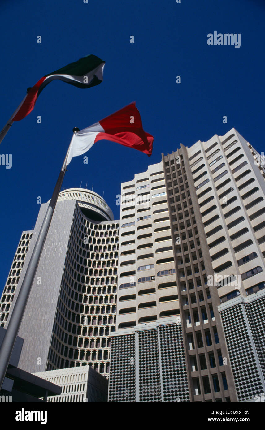 UAE Dubai Deira Tower. À la recherche jusqu'à l'immeuble de grande hauteur, drapeaux au vent en premier plan. Banque D'Images