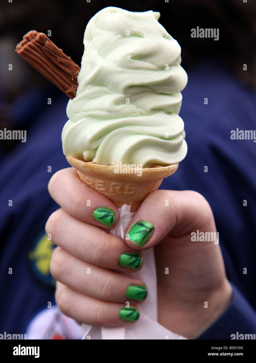 St Patrick s Day ice cream cone tenu par une jeune fille portant du vernis à ongle vert Irlande Carrickmacross Banque D'Images