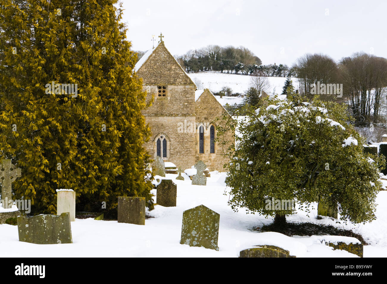 Neige de l'hiver à St Peters Church dans le village de Cotswold Duntisbourne Abbots, Gloucestershire Banque D'Images