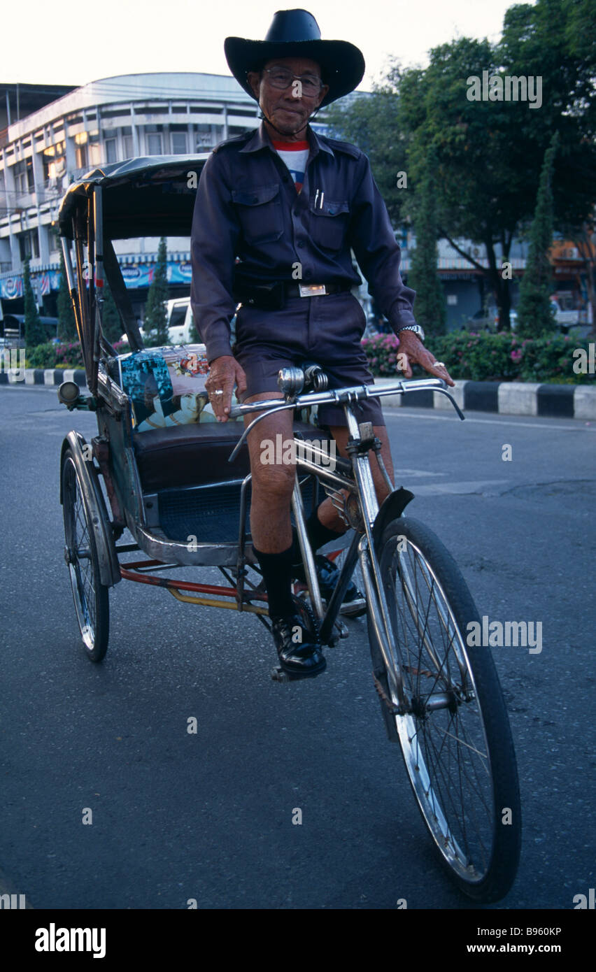 Nord Thaïlande Chiang Mai Cyclo cyclo tricycle en uniforme d'influence du pilote son vélo pousser dans la rue. Banque D'Images