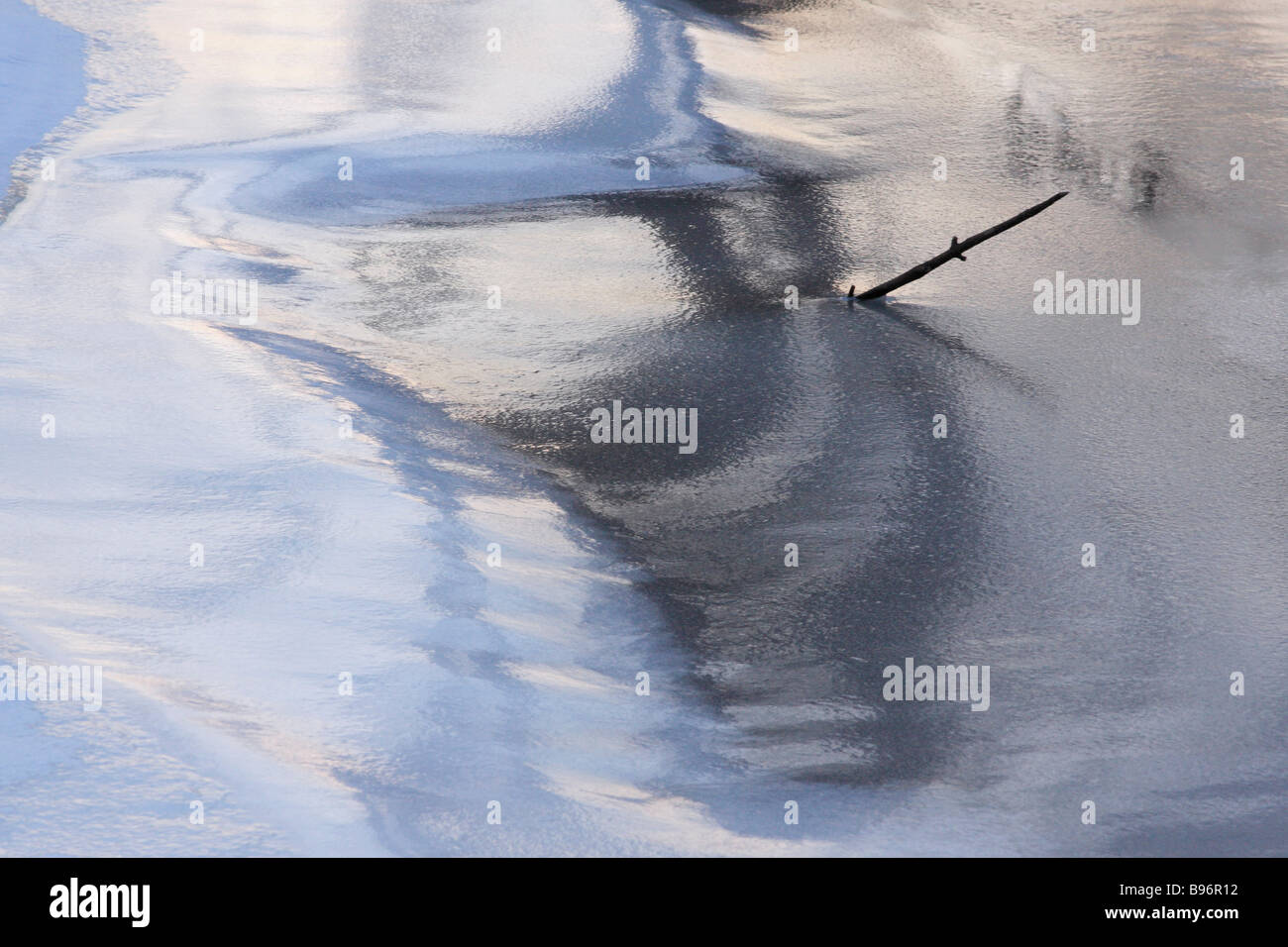 Abstract. La glace de rivière reflétant les arbres et ciel au crépuscule. Banque D'Images