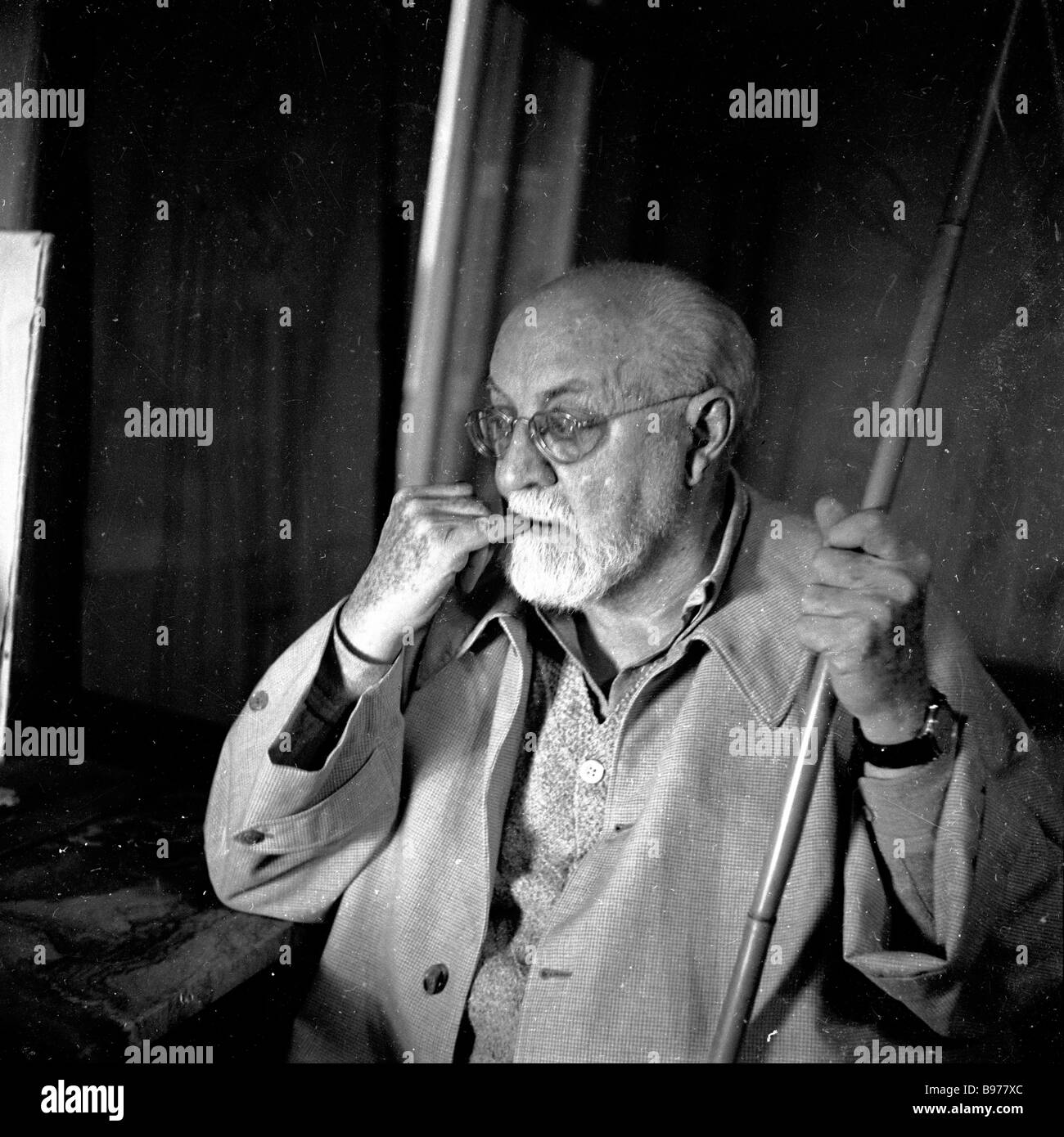 Le célèbre artiste français Henri Matisse avec sa longue perche dans son atelier en France, 1951. Son projet majeur à cette époque fut l'Vence Chapelle design. Banque D'Images