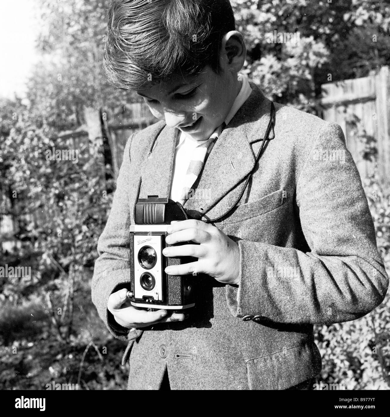 1950s, historique, regardant vers le bas son viseur, un adolescent dans un jardin utilisant un appareil photo Kodak Brownie reflex Box pour prendre une photo, Angleterre, Royaume-Uni. Banque D'Images