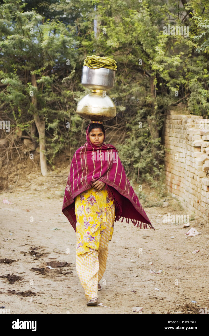 Femme portant de l'eau qu'ils ont recueillies auprès de l'Inde bien Rhajasthan PLAT000024 Banque D'Images