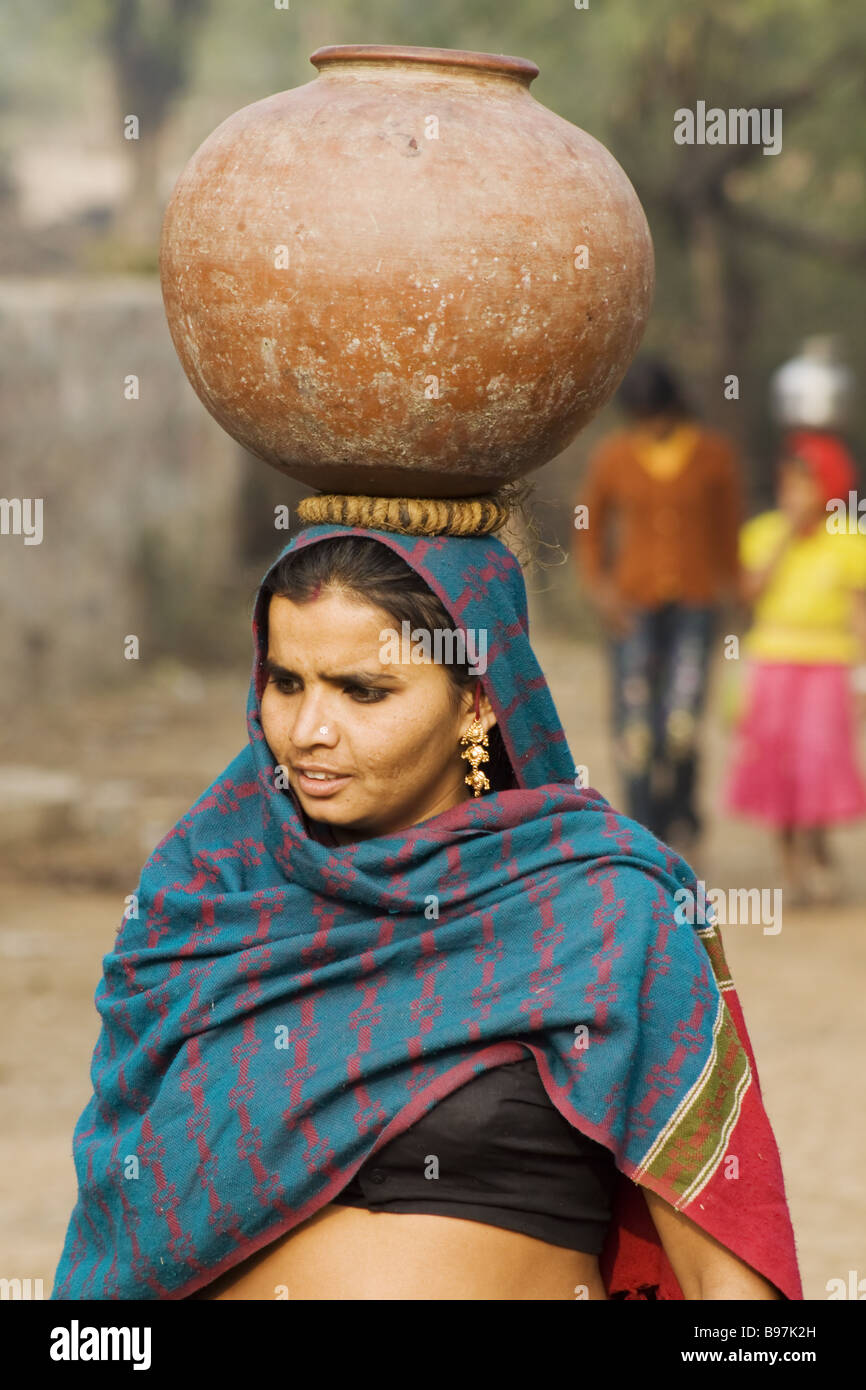 Femme portant de l'eau qu'ils ont recueillies auprès de l'Inde bien Rhajasthan PLAT000021 Banque D'Images