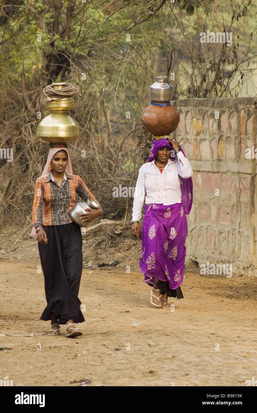 Les femmes portant de l'eau qu'ils ont recueillies auprès de l'Inde bien Rhajasthan PLAT000013 Banque D'Images