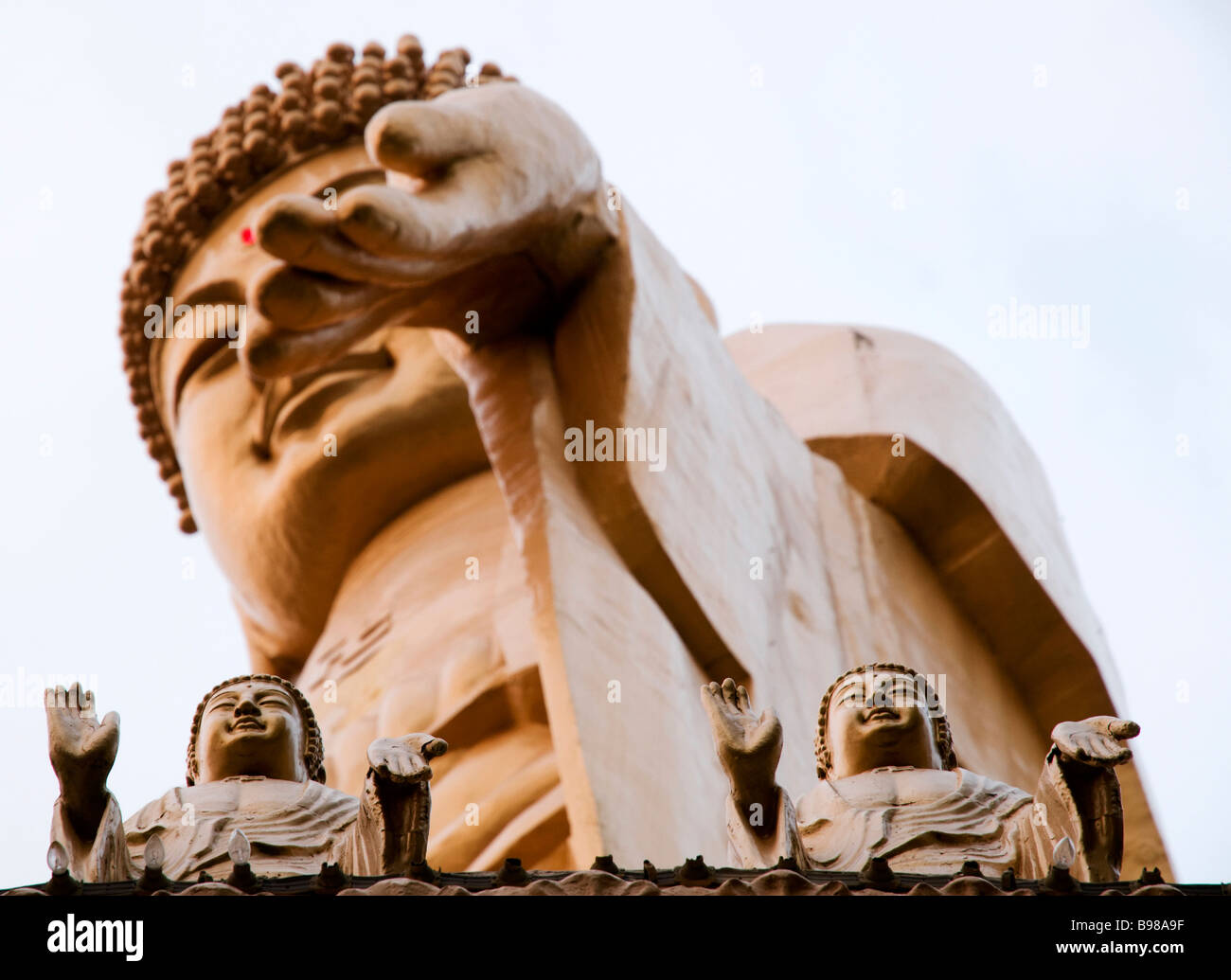 Immense statue de Bouddha à Taiwan, Fokuangshan, avec deux petites statues ci-dessous à la recherche de haut et en montrant des pécheurs Banque D'Images