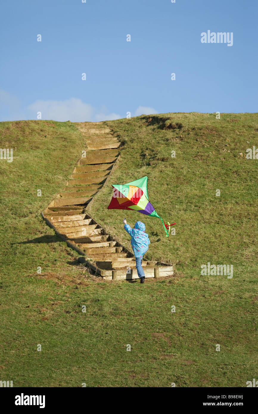Jeune fille avec flying kite monte hill Banque D'Images