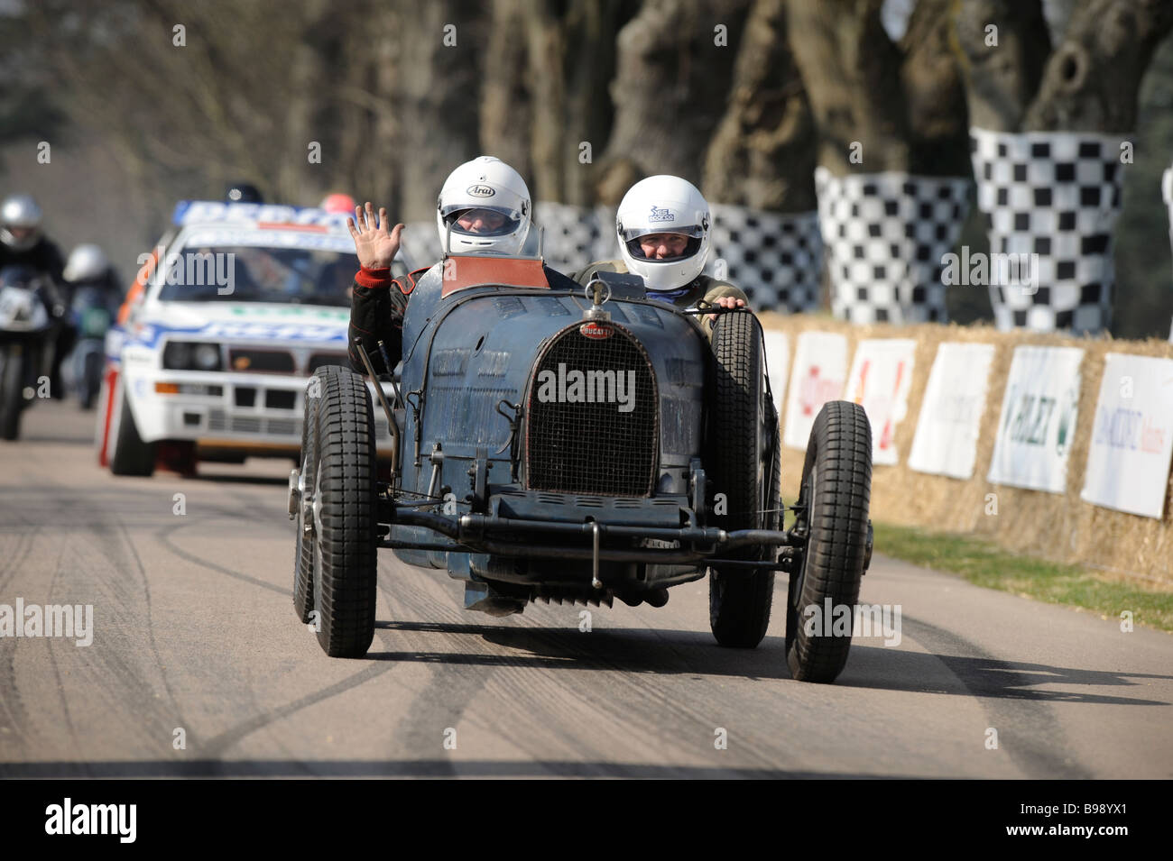 Voitures de course à moteur font leur chemin vers la ligne de départ à Goodwood Festival of Speed dans le West Sussex. Banque D'Images