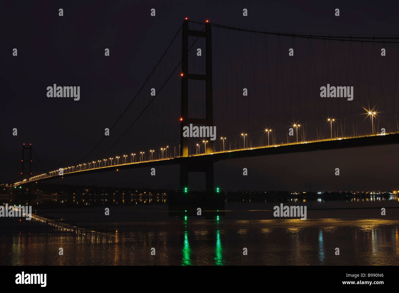 Le Humber Bridge la marée basse à photo de nuit à partir de la rive sud de la rivière Humber, dans le Lincolnshire, Angleterre, RU Banque D'Images