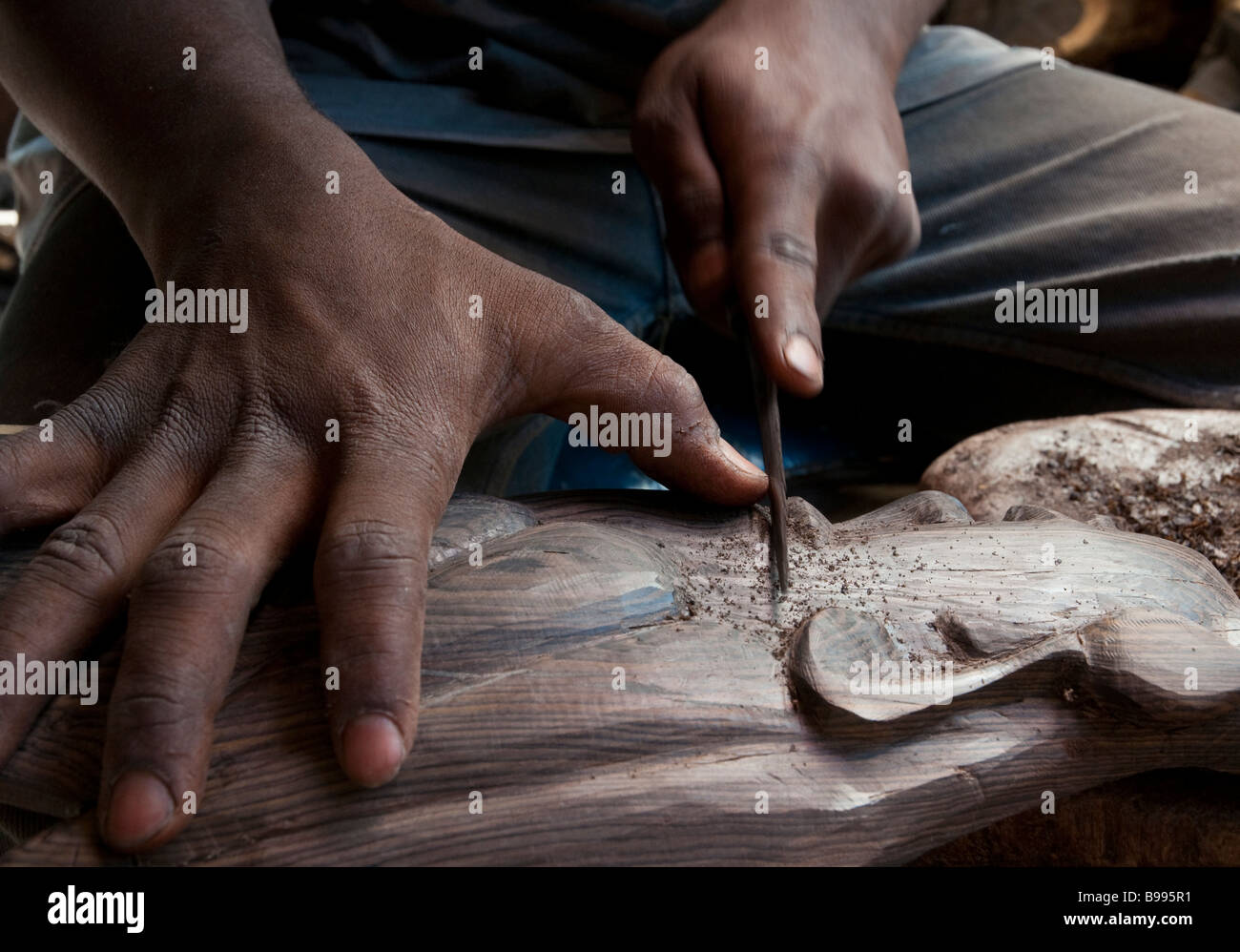 L'Afrique de l'Ouest BAMAKO Mali marché artisanal close up of hands travaillant sur sculpture en bois Banque D'Images