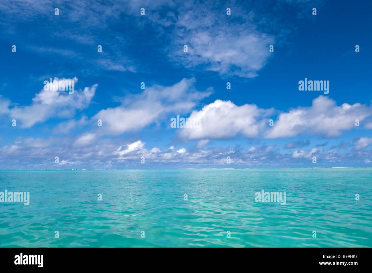 Turquoise émeraude mer rencontre whisps de nuages dans le ciel bleu du Pacifique sud juste à côté de Aitutaki, Îles Cook Banque D'Images