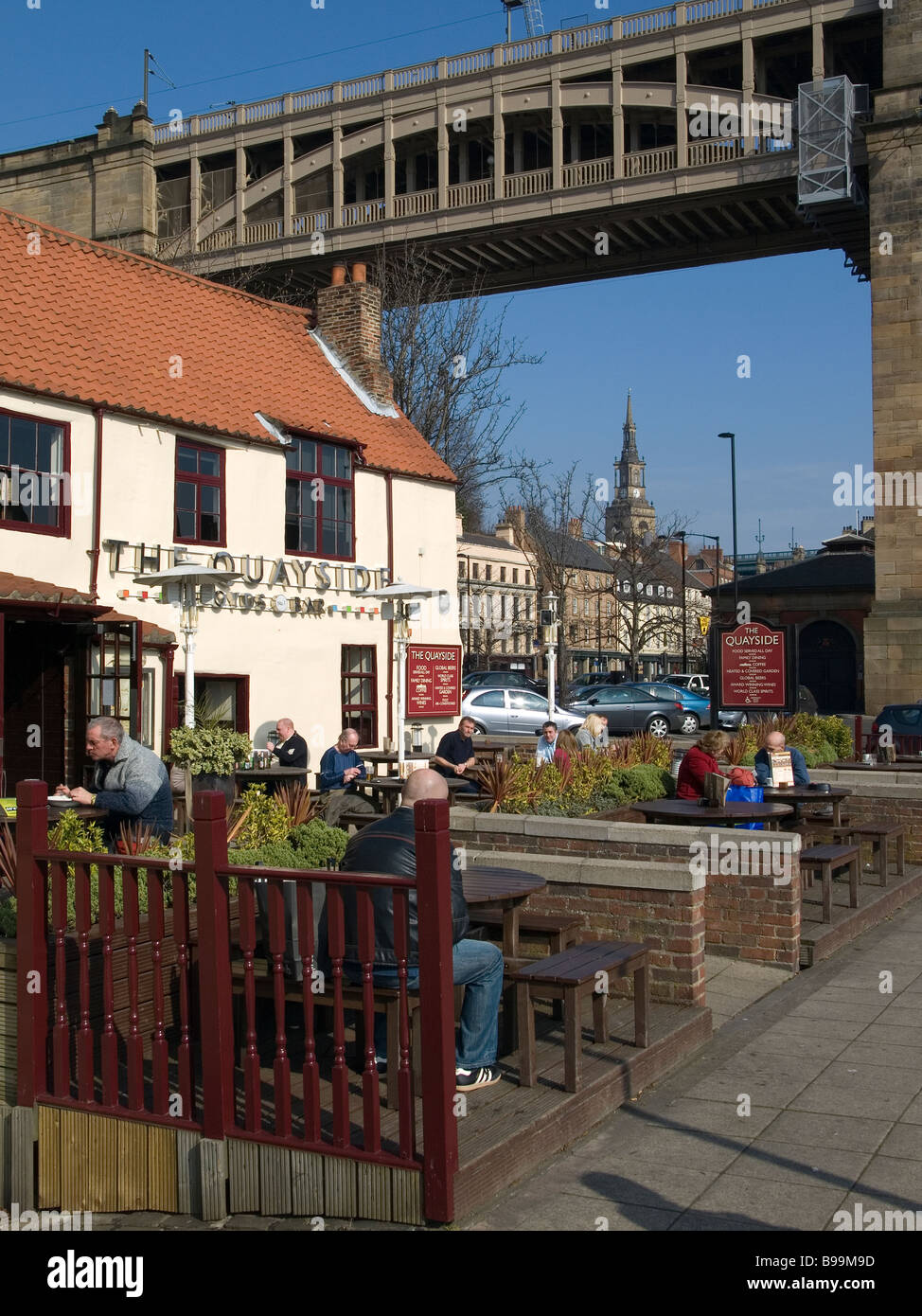 Bar Lloyds sur la rive de la rivière Tyne Newcastle avec le haut niveau historique route rail bridge derrière Banque D'Images