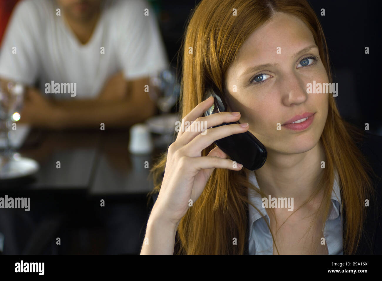 Woman holding cell phone, smiling at camera Banque D'Images