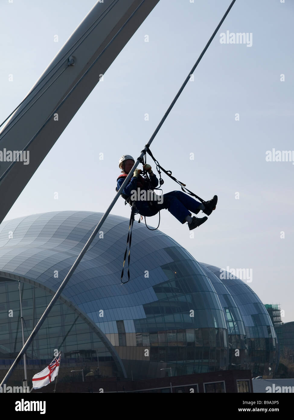 À l'aide de l'Ouvrier accès sur corde à grimper sur le Gateshead Millennium Bridge Banque D'Images