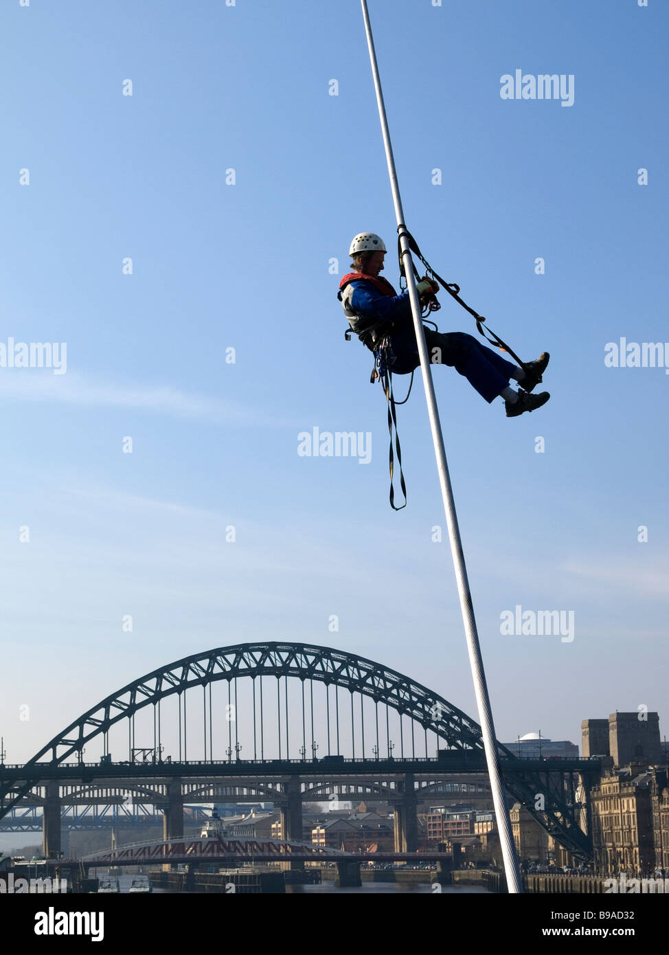 À l'aide de l'Ouvrier accès sur corde à grimper sur le Gateshead Millennium Bridge Banque D'Images