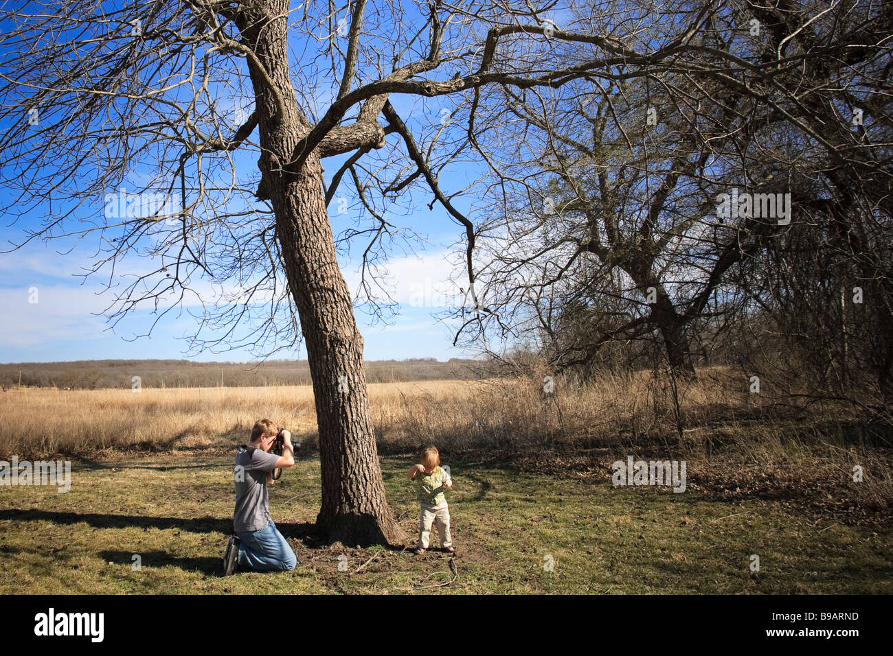 Un photographe de l'adolescence se concentre sur un jeune garçon de deux ans inconscient à la Réserve des prairies à herbes hautes près de Pawhuska, Oklahoma. Banque D'Images