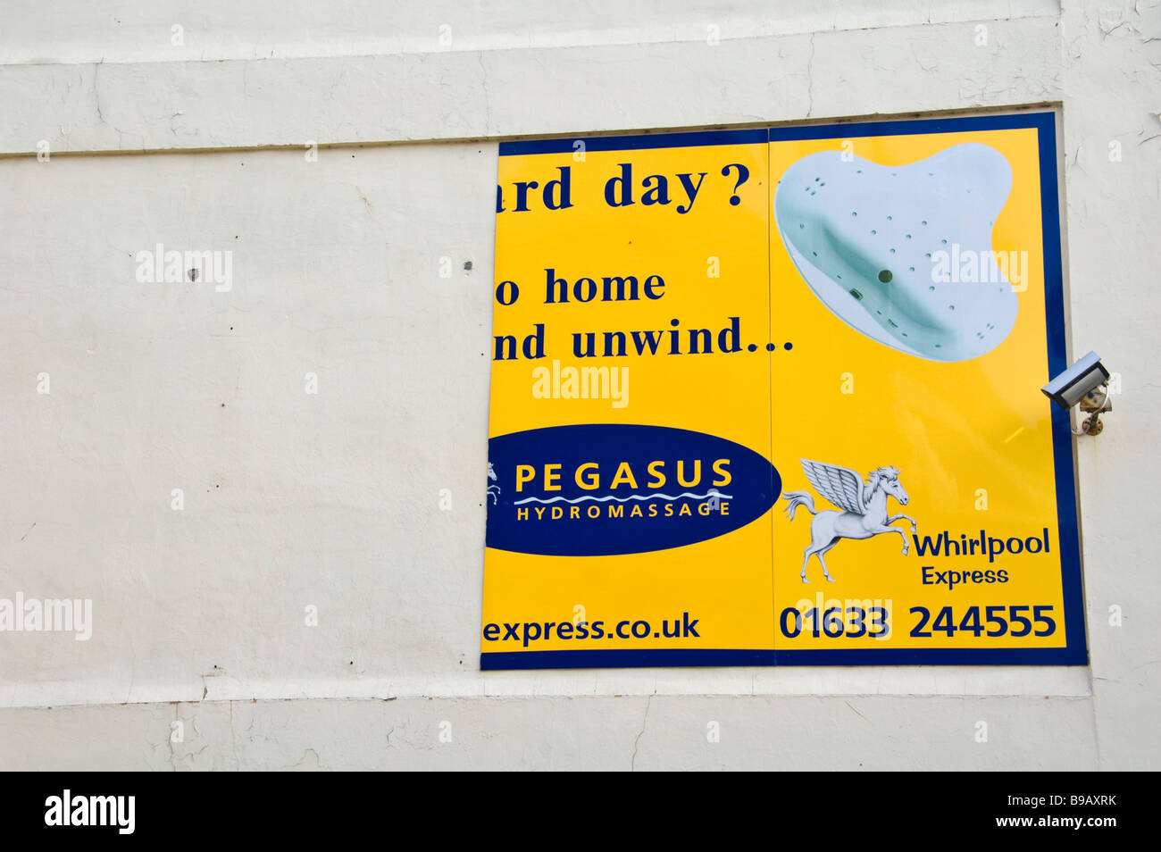 La moitié panneau publicitaire pour des bains à remous sur le côté du bâtiment dans Newport South Wales UK Banque D'Images