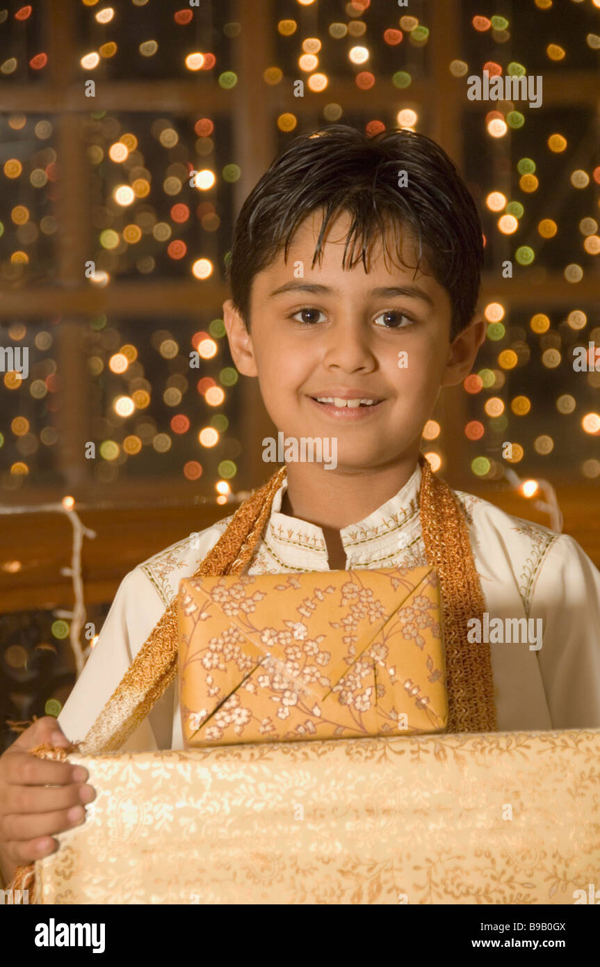 Boy holding Diwali gifts and smiling Banque D'Images