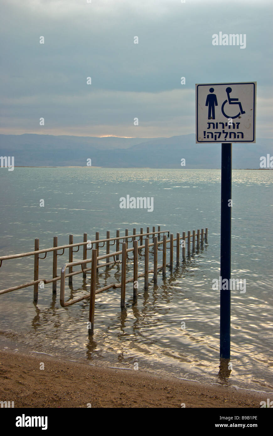 Garde-corps en acier inoxydable et de permettre à des personnes handicapées de la rampe d'accès à la plage pour les baigneurs des eaux de mer Morte flottant dans ville touristique de Ein Bokek Banque D'Images