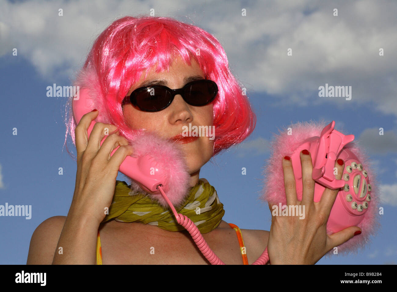 Femme avec une perruque rose téléphone rose Banque D'Images