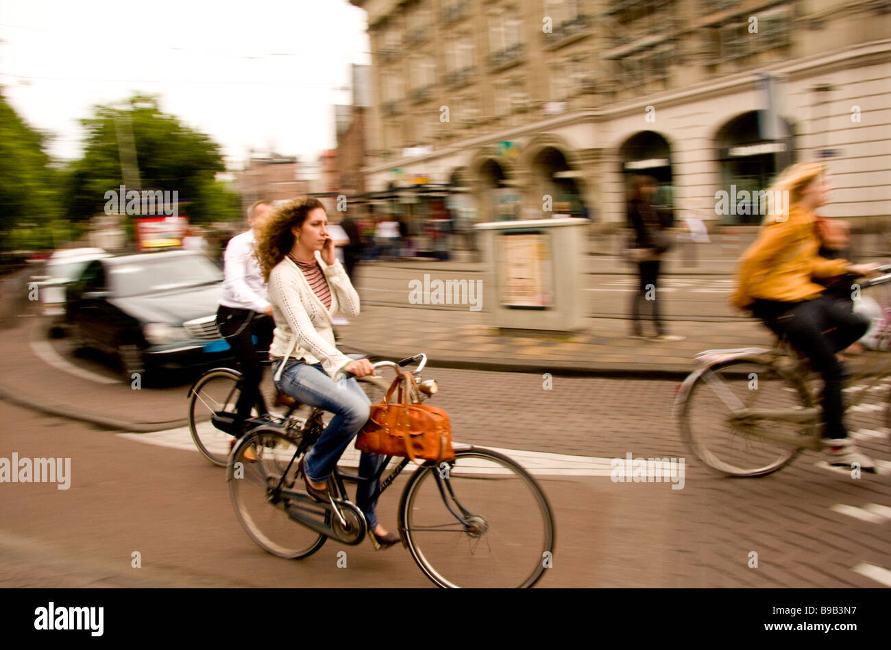 Woman talking on mobile-phone tout en vélo à Amsterdam Holland Banque D'Images