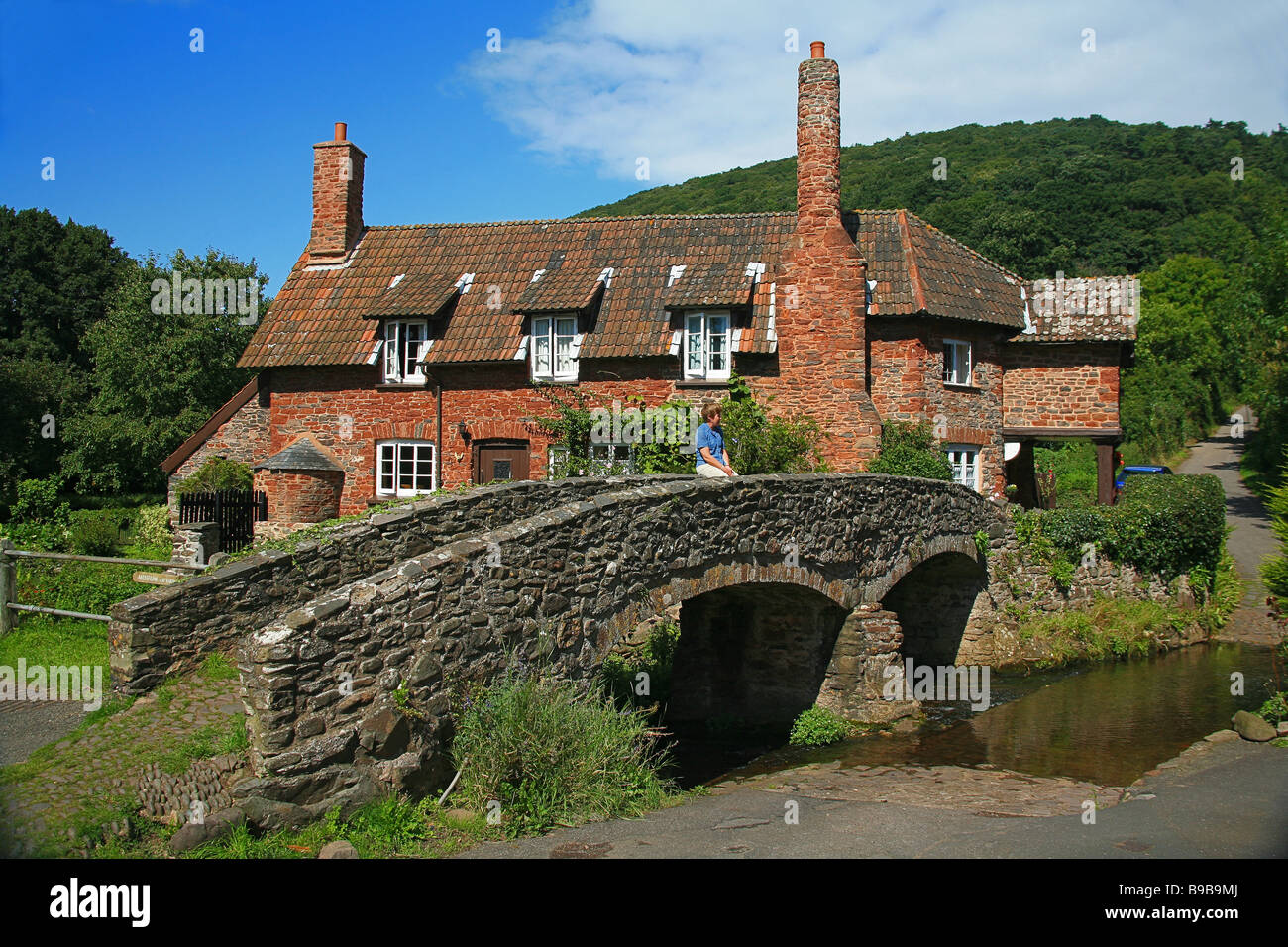 Chalets traditionnels en pierre et pack horse bridge dans le village de Allerford, Somerset, England, UK Banque D'Images