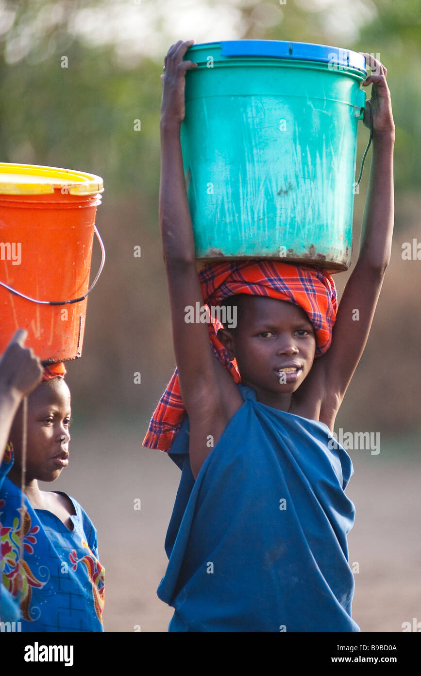 Les enfants africains portant de l'eau home Banque D'Images