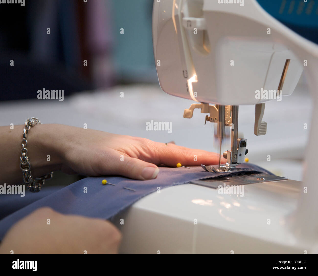Les mains de womans et celle de la machine à coudre Banque D'Images