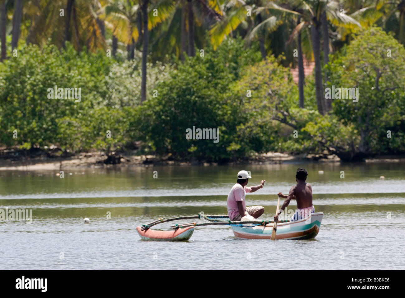 Deux pêcheurs du village sur une petite pirogue à voile à Chilaw, lagune, Sri Lanka. Banque D'Images