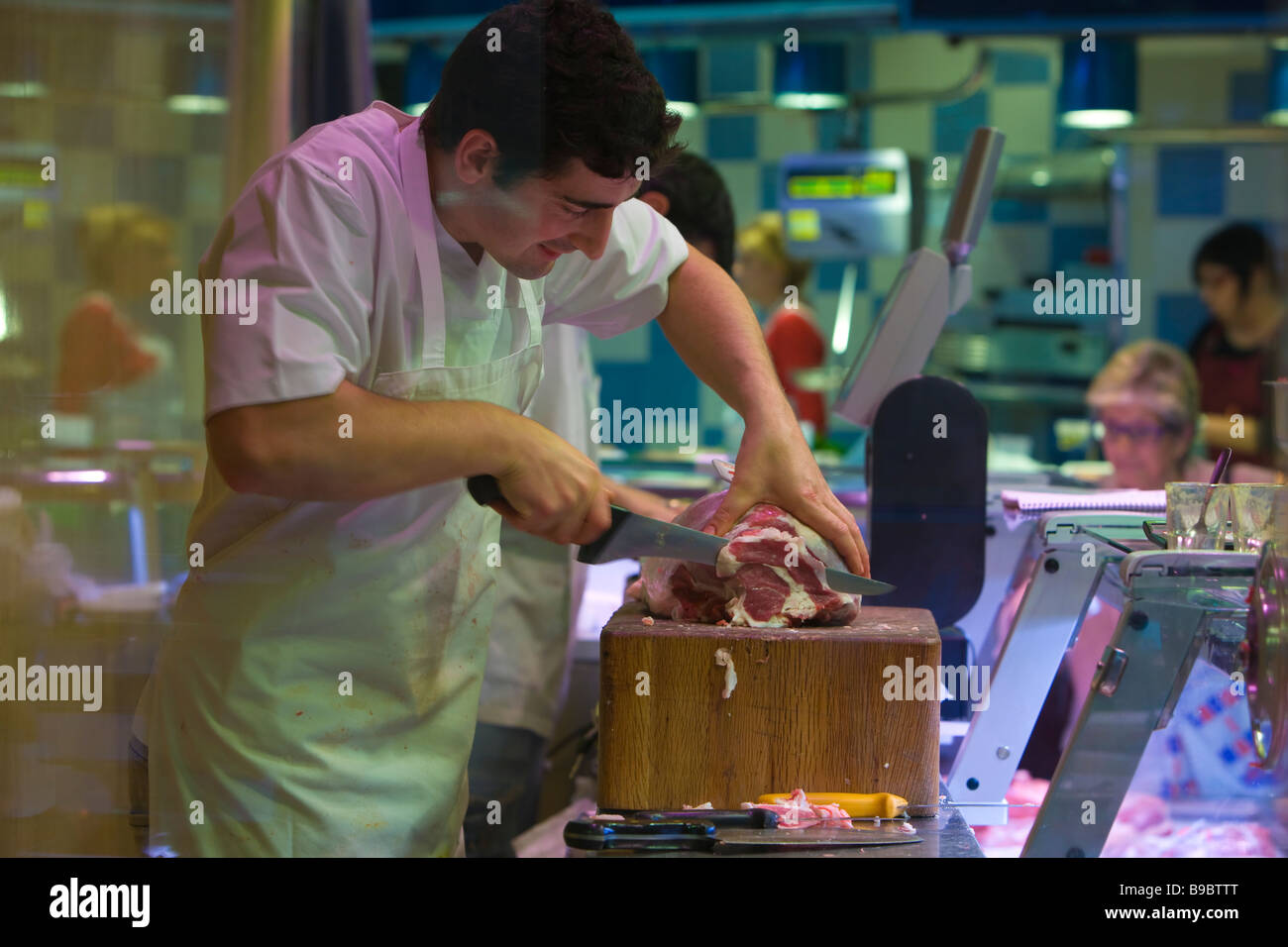 Boucher au travail de la viande en tranches de prosciutto italien épicé salés à sec sec guéri jambon crudo antipasto à l'os de porc Parma Banque D'Images