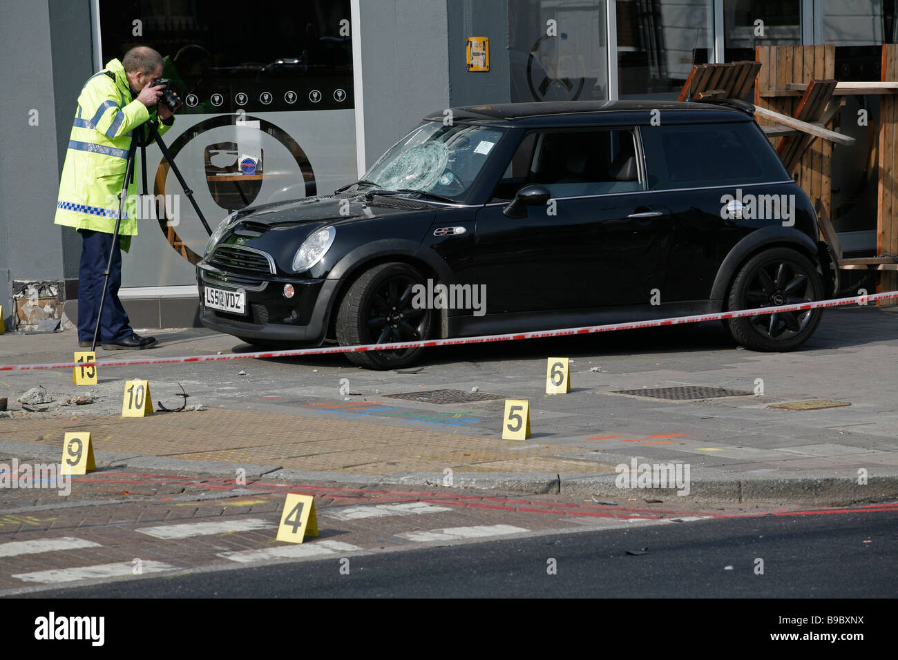 La police scientifique prendre preuve après un accident de la route laisse une voiture sur le trottoir, sur Clapham High Street, Londres du sud. Banque D'Images