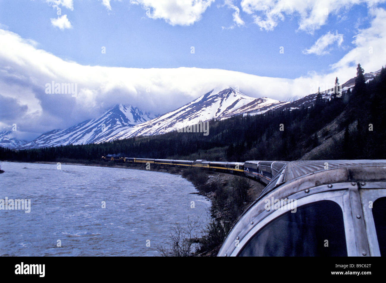Alaska Croisière-excursion en train de Denali en passant à côté du lac longue chaîne de voitures des nuages blancs à l'horizon bas Banque D'Images