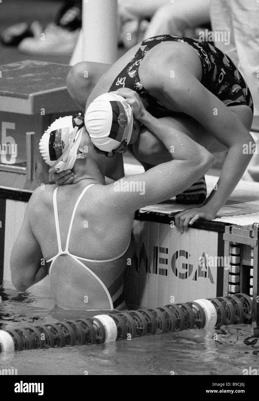 B Meinike Kristin Otto gauche et droit des membres de l'équipe de natation féminine de RDA pour féliciter l'un l'autre sur leur victoire à la Banque D'Images