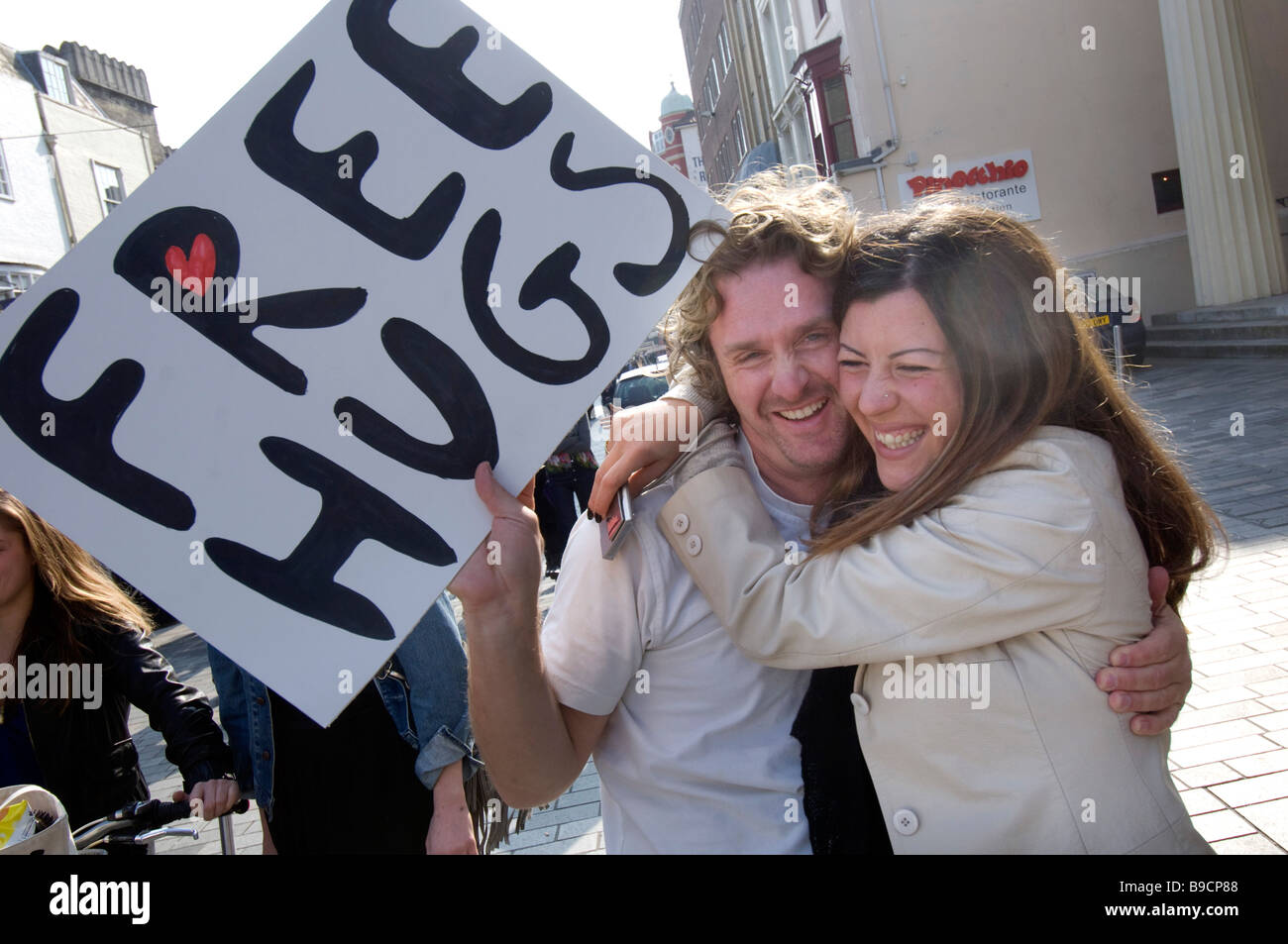 Un jeune couple de se donner mutuellement un spontanious hug dans le centre de Brighton Banque D'Images