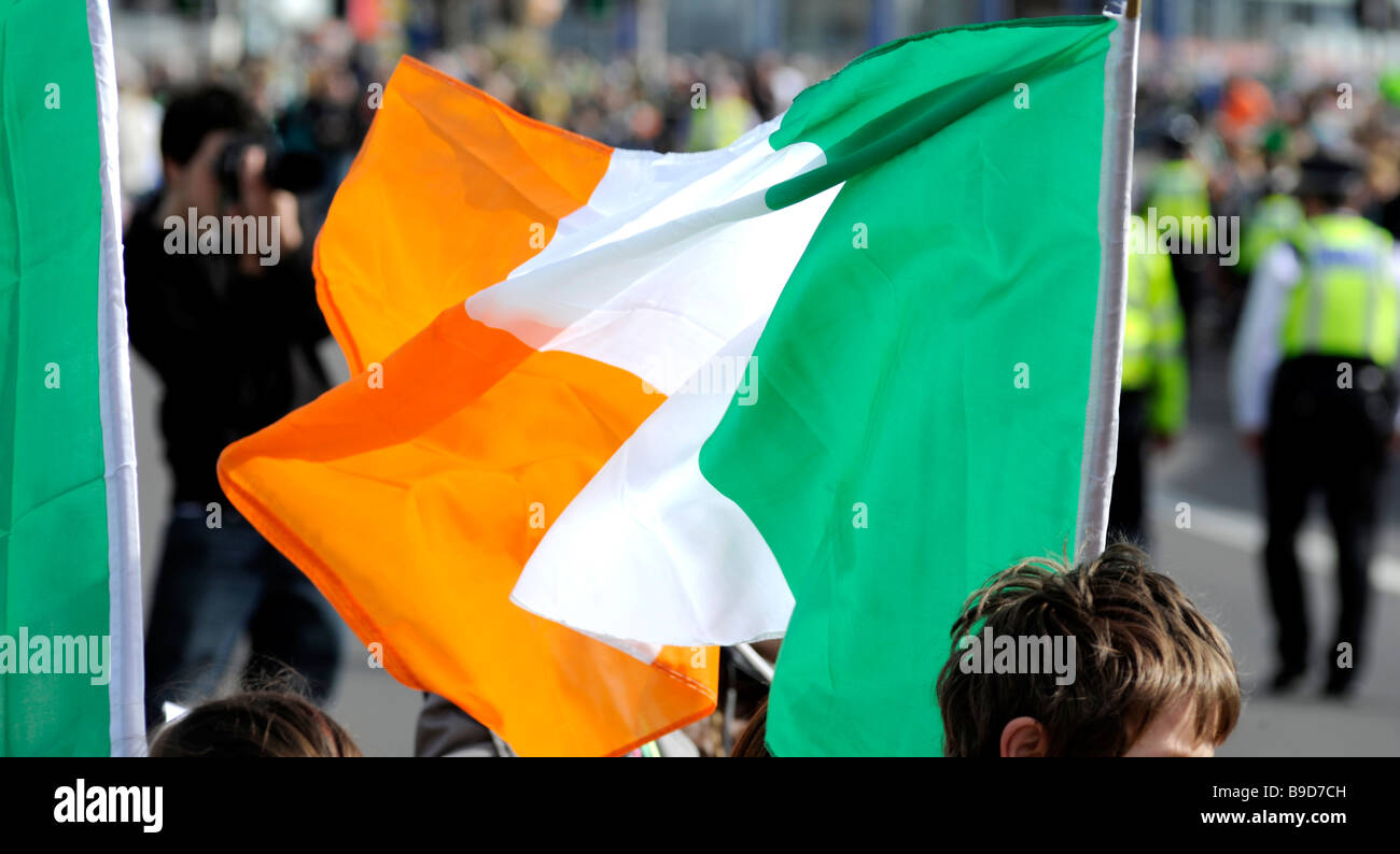 Birmingham St. Patrick's Parade, Digbeth, Birmingham, Angleterre, Royaume-Uni. Un drapeau irlandais avec la police et photographe à l'arrière. Banque D'Images