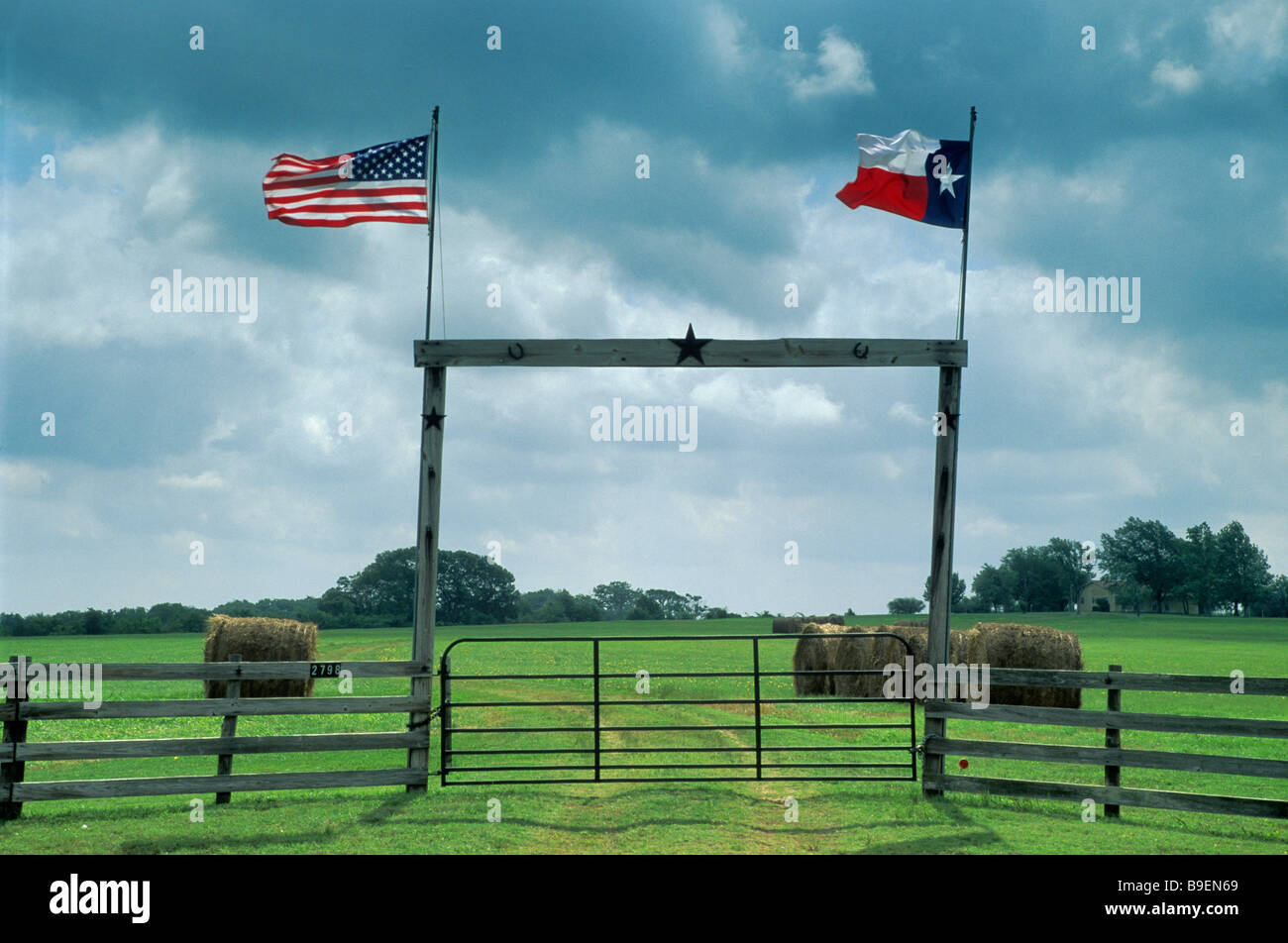 Ranch bois gate avec TX et drapeaux américains sur TX 90 l'autoroute près de Anderson Grimes County Texas USA Banque D'Images